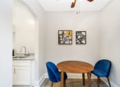 Thumbnail 11 of 15 - a dining area with a wooden table and two blue chairs