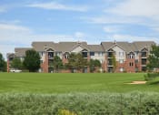 Thumbnail 37 of 40 - Westlake Greens brick apartment buildings with green grass and trees in front