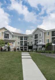 Apartment complex with a walkway in front.