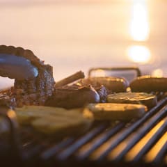 a steak being cooked on a grill with tongs