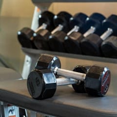 a pair of dumbbells sitting on a table in a gym