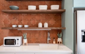 a small kitchen with a microwave and shelves
