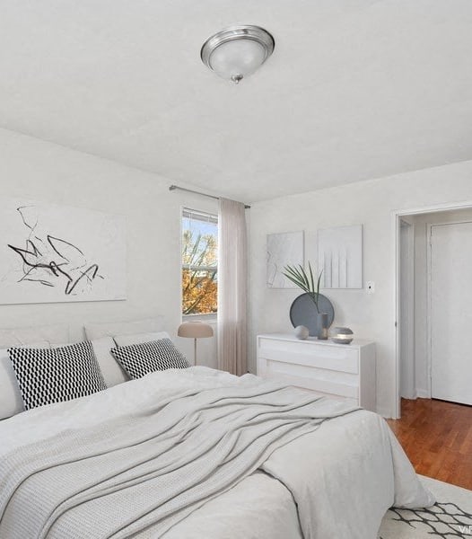 a white bedroom with a bed and two windows