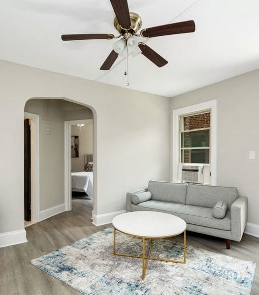 a living room with a couch coffee table and a ceiling fan