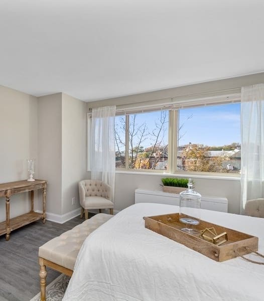 a bedroom with a bed sitting next to a window