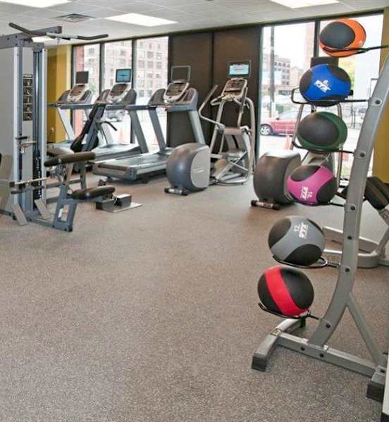 A gym with a variety of equipment including treadmills, weights, and exercise machines.