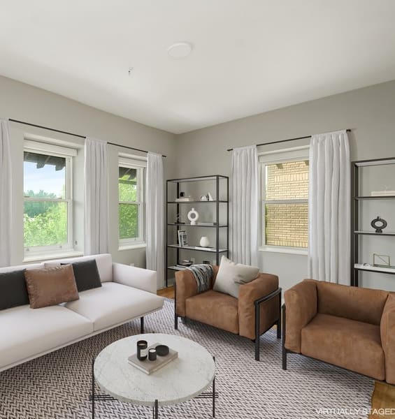 a living room with a white couch and two brown chairs