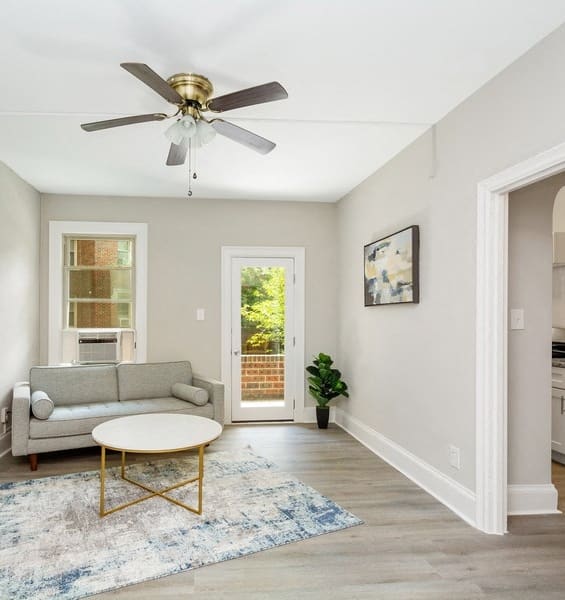 a living room with a couch coffee table and a ceiling fan