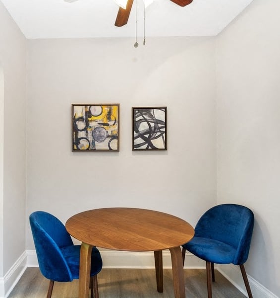 a dining area with a wooden table and two blue chairs