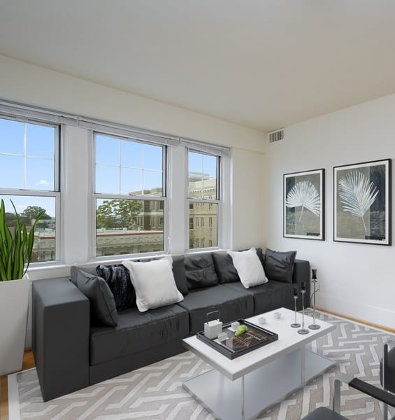 a living room with a black couch and a white coffee table at 1841 Columbia Road Apartments, Washington, Washington DC