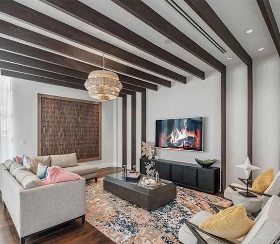 A modern living room with a grey sofa, a coffee table, and a fireplace.