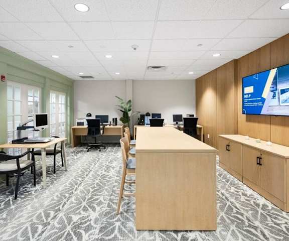A modern office space with a large screen TV mounted on the wall.
