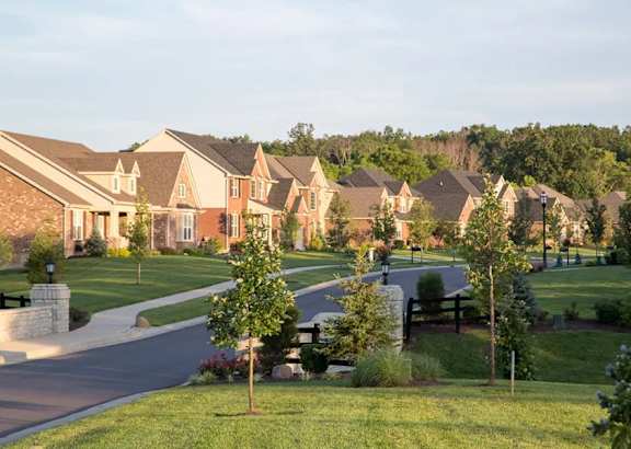 A suburban neighborhood with houses and a tree-lined street.