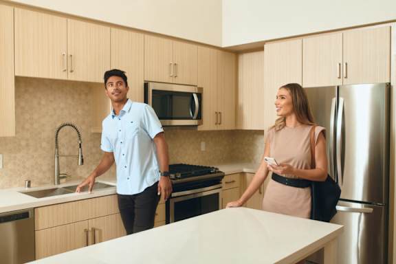 A man and a woman are standing in a kitchen.