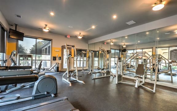 the gym has a wall of dumbbells and exercise equipment at Waterstone at Cinco Ranch, Katy, TX, 77450