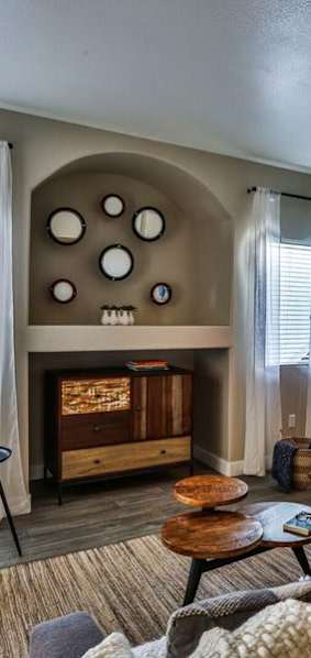 A bedroom with a bed, a mirror, and a window with blinds.