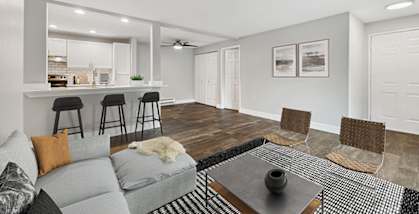 Model Living Room with Wood-Style Flooring and View of Kitchen at Central Flats Apartments in Kent, WA.