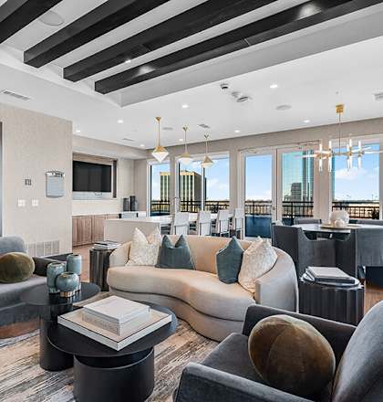 Community Clubhouse with Lounge Furniture and Kitchenette Area at Ovation at Galatyn Park Apartments located in Richardson, TX.