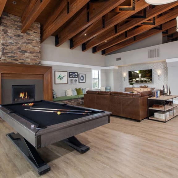 a large living room with a pool table and a fireplace at The Reserve at 4S Ranch, California