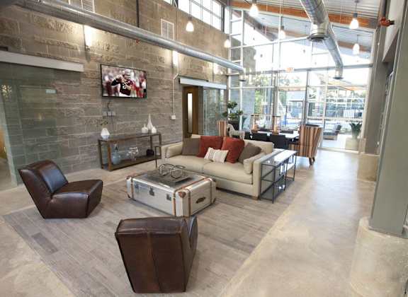 A living room with a brown leather chair and a white couch.