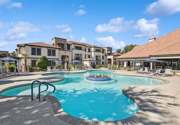 a swimming pool with a fountain in front of a building