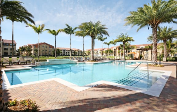 a large swimming pool with palm trees and buildings in the background at The Atlantic Doral, Florida, 33178