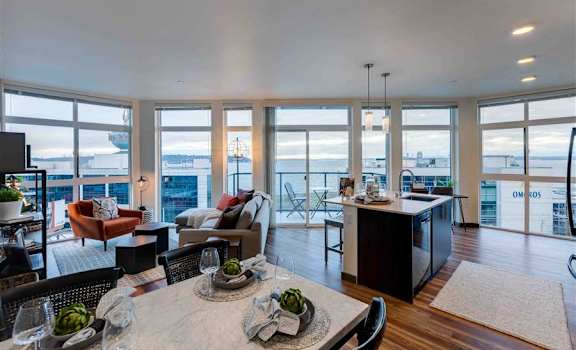 a living room with a table and chairs next to a kitchen