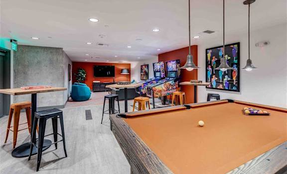 a games room with a pool table and arcade games