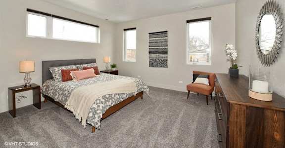 a bedroom with a bed and a desk and some windows