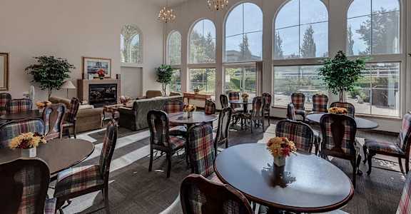 A room with a fireplace and a large window at VINTAGE AT Sequim Apartments, Sequim ,Washington