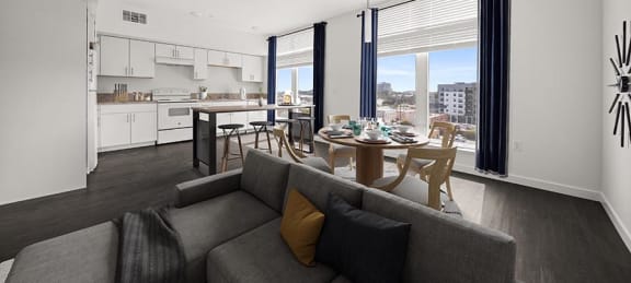 a living room with a couch and a table with chairs and a kitchen in the background at Grand and Linden Family Apartments, South San Francisco