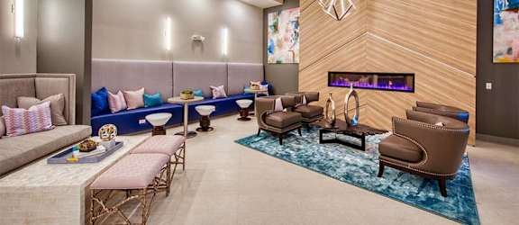 a lobby with couches chairs and a fireplace