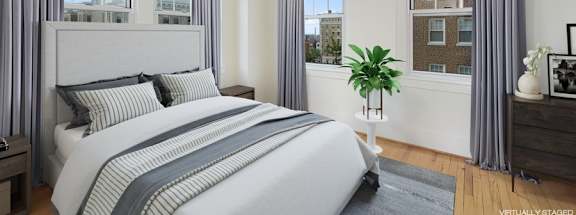 a bedroom with a bed and three windows at 1841 Columbia Road Apartments, Washington, Washington DC
