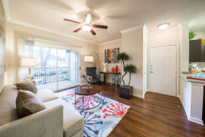 Living room with wood-style floors and balcony/patio entrance,