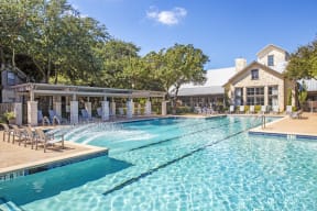 Apartments For Rent In North Austin, TX - Resort Class Swimming Pool With Plenty Of Lounge Chairs, Shaded Gazebo, And Club House In The Background.