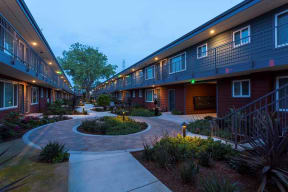 Evening view of courtyard and buildings l The Parc at Pruneyard Apartments