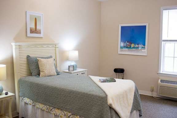 a bedroom with a bed and two windows