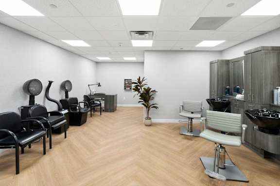 A room with black and white chairs and a wooden floor.