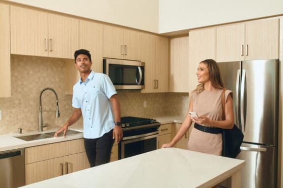 a man and a woman standing in a kitchen