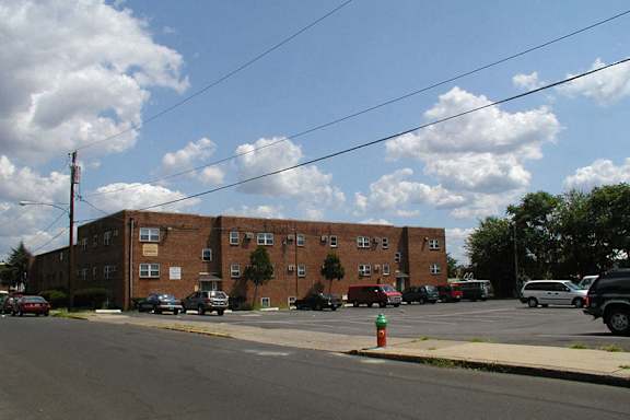A parking lot with cars and a fire hydrant in front of a brick building.