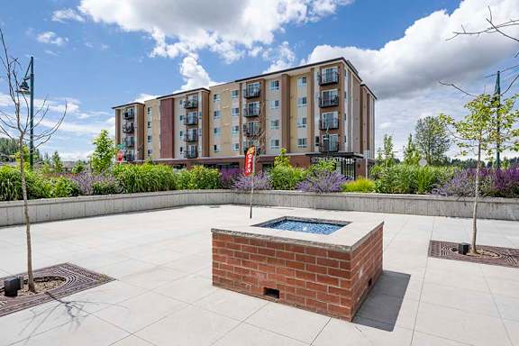A modern building with a courtyard and a brick fire pit at FARM BY VINTAGE, MILL CREEK, WA 98012