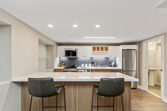 a kitchen with a large island with two stools in front of it