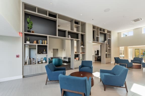 a lounge area with blue chairs and a coffee table
