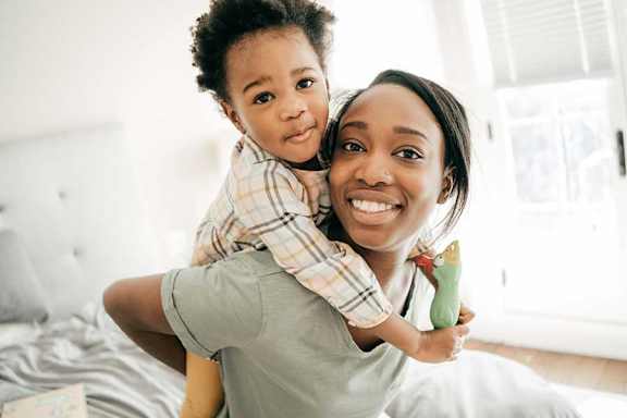 A woman is holding a child in her arms.
