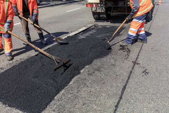a group of workers working on a road