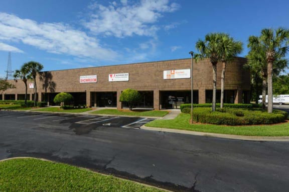 a large brick building with palm trees in front of it