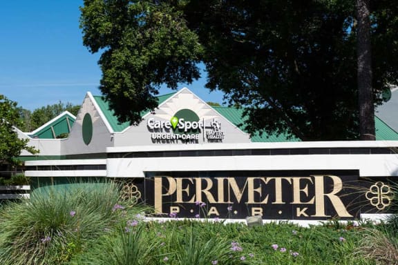 a sign in front of a building with a green roof