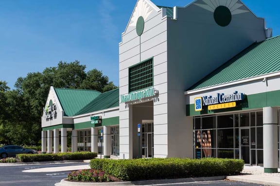 a building with a green roof and a yellow sign
