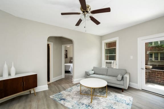 a living room with a couch coffee table and a ceiling fan