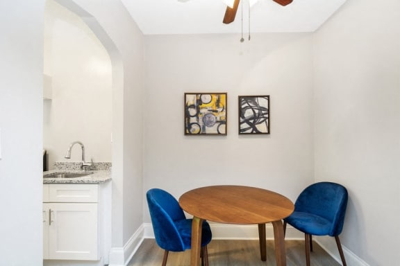 a dining area with a wooden table and two blue chairs